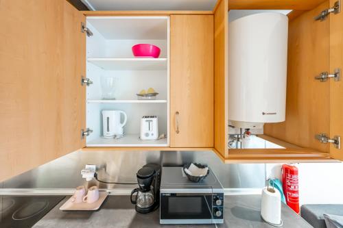 a kitchen with wooden cabinets and a microwave at Casas do Olival Apartments in Lisbon