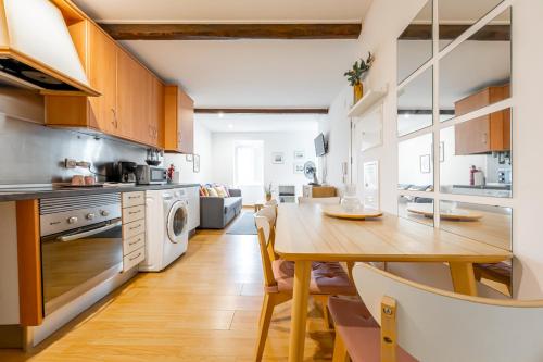 a kitchen with a wooden table and a dining room at Casas do Olival Apartments in Lisbon