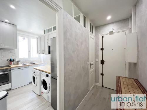 une cuisine avec des armoires blanches et une laveuse et une sécheuse dans l'établissement Urban Flat 180 - Charmant Appartement au coeur du Marais, à Paris