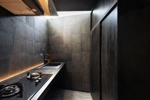 a black bathroom with a sink and a counter at T Lofts in Seminyak