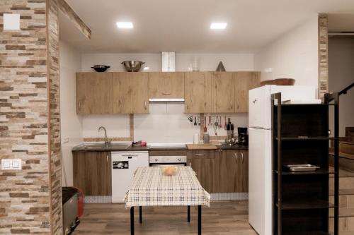a kitchen with a table and a white refrigerator at La Via Verde in Miguel-Ibáñez