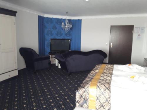 a hotel room with a bed and a desk and a television at Mucha OHG Hotel Sembziner Hof in Klink