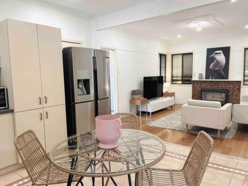 a living room with a glass table and chairs at D139 Norfolk Cottage Stay in Maribyrnong