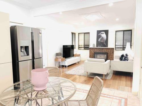 a living room with a glass table and a fireplace at D139 Norfolk Cottage Stay in Maribyrnong