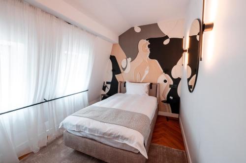 a bedroom with a bed and a painting on the wall at Ecletico Villa in Bucharest