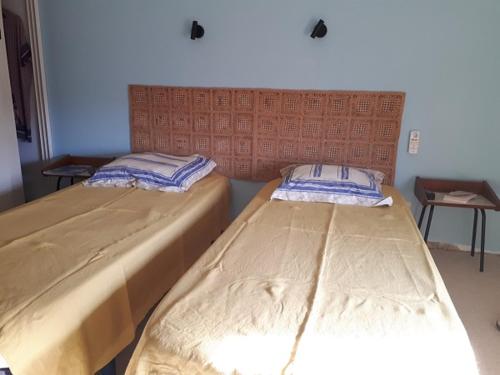 deux lits côte à côte dans une pièce dans l'établissement beaurivage, à Saint-Raphaël