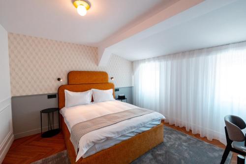 a bedroom with a large bed with a wooden headboard at Ecletico Villa in Bucharest