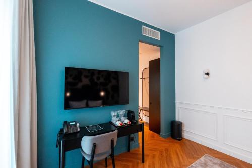 a room with a desk with a television on a blue wall at Ecletico Villa in Bucharest