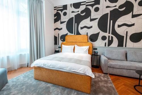 a bedroom with a bed and a couch at Ecletico Villa in Bucharest
