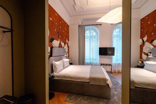 a hotel room with a bed and a mirror at Ecletico Villa in Bucharest