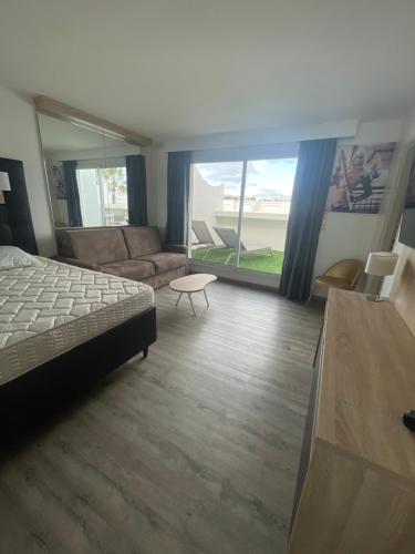 une chambre avec un lit et un salon dans l'établissement village naturiste - Résidence Le jardin d'éden 