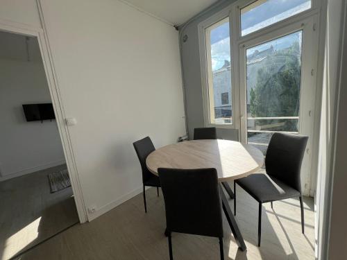 une salle à manger avec une table et des chaises et une fenêtre dans l'établissement Le Robespierre, à Rouen