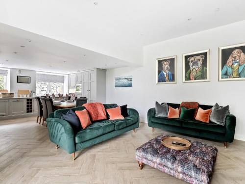 a living room with two green couches and a table at Valerian Lodge in Harlech