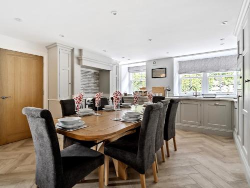 a kitchen and dining room with a wooden table and chairs at Valerian Lodge in Harlech