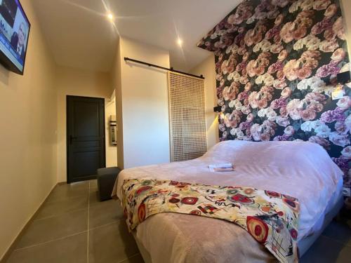 - une chambre avec un lit orné d'un mur fleuri dans l'établissement Calme et volupté avec animaux, à Saint-Jean-Lasseille