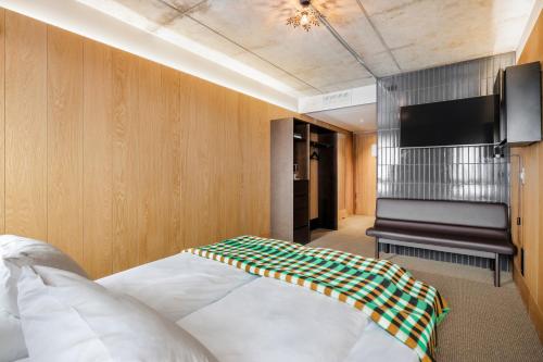 a bedroom with a bed and a flat screen tv at Skostredet Hotel in Bergen