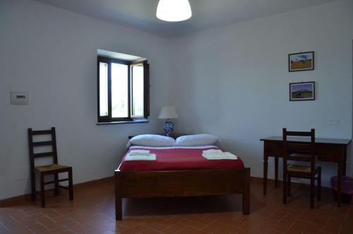 a bedroom with a bed with two chairs and a table at Agriturismo Fiore in Viggianello