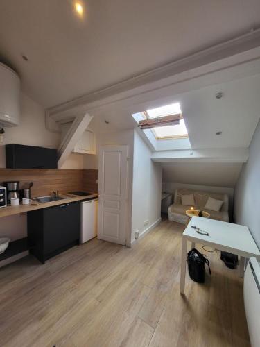 une cuisine et un salon avec une table dans une pièce dans l'établissement Cocon Villeurbanne Charpennes, à Villeurbanne