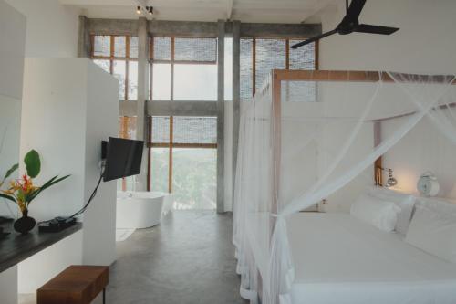 a bedroom with a bed and a tv and a window at Villa Amma Erna - Galle in Galle