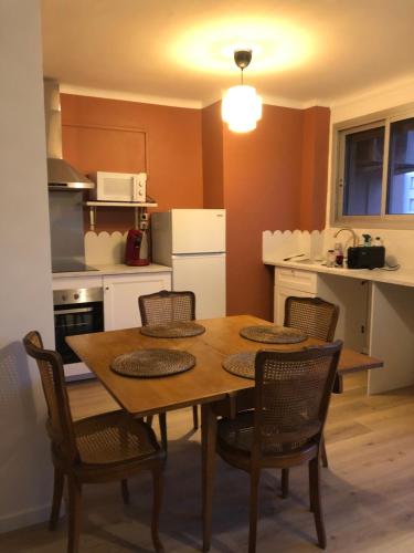 - une cuisine avec une table et des chaises en bois dans la chambre dans l'établissement Appartement sainte Marguerite proche métro et stade vélodrome, à Marseille