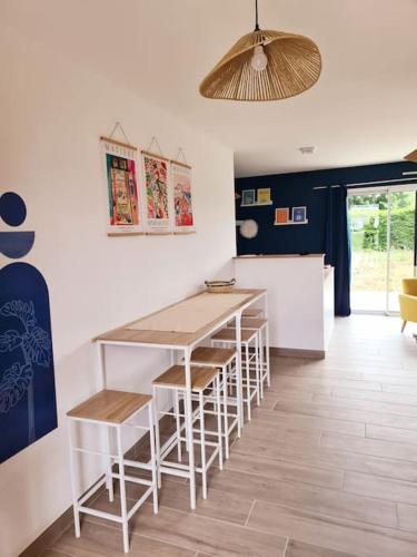 une cuisine avec une table et des chaises dans une pièce dans l'établissement La Riviera - Site du Futuroscope - 3 chambres, à Chasseneuil-du-Poitou