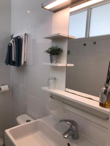 une salle de bain avec un lavabo et un miroir dans l'établissement La Gimoniere, à La Barre-de-Monts