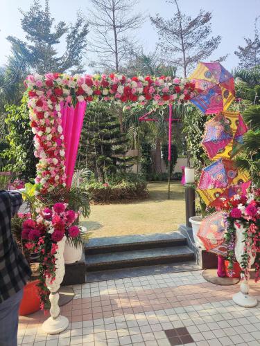 an arch with flowers and umbrellas in a park at Gazebo Inn & Suites Medanta in Gurgaon