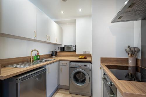 a kitchen with a washing machine and a sink at Terracotta Apartment, free WiFi & parking, coastal location in New Brighton