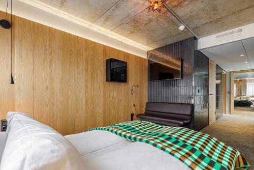 a bedroom with a bed and a chair at Skostredet Hotel in Bergen