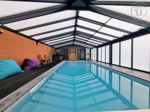 une piscine intérieure avec toit dans l'établissement Gîte de charme avec piscine, spa et sauna - Tout inclus, à Beaurepaire-sur-Sambre, Parc Naturel Avesnois - FR-1-510-213, à Beaurepaire-sur-Sambre
