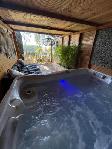 a jacuzzi tub in a house with a patio at Cabane bien belge avec cinéma et jacuzzi in Lasne