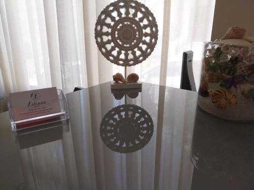 a glass table with a cake and a box on it at Hotel Liliana in Agia Marina Aegina