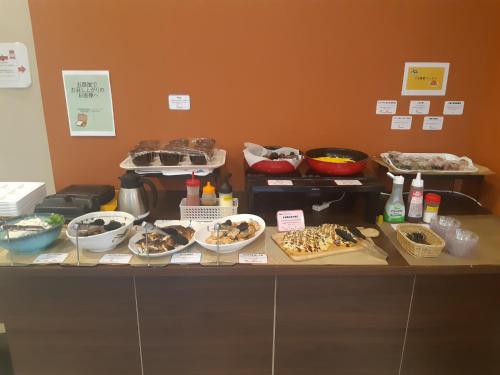 a counter with many bowls of food on it at Urbain Hiroshima Central in Hiroshima