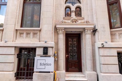 a building with a door and a sign in front of it at Ecletico Villa in Bucharest