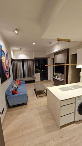 a living room with a blue couch and a kitchen at Star Residence Pool View 2br Unit Floor 8 in Kuala Lumpur