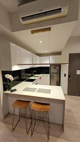 a kitchen with a white counter and two chairs at Star Residence Pool View 2br Unit Floor 8 in Kuala Lumpur