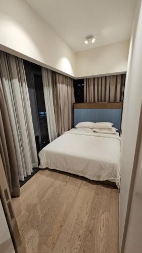 a bedroom with a white bed and some windows at Star Residence Pool View 2br Unit Floor 8 in Kuala Lumpur