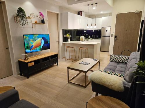 a living room with a couch and a tv and a kitchen at Star Residence 2br Unit Floor 46 in Kuala Lumpur
