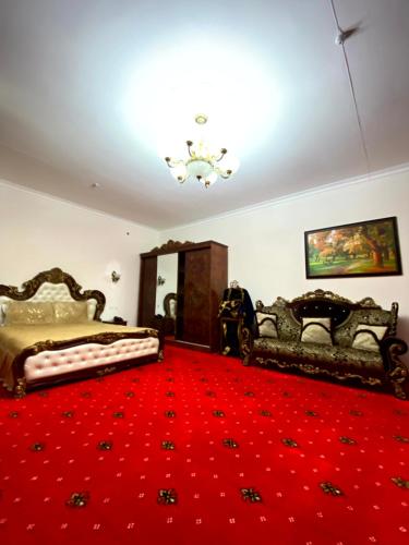 a bedroom with two beds and a red carpet at Qibla Tozabog in Khiva