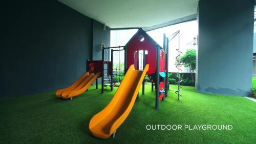 a playground with a slide in a room with grass at Star Residence 2br Unit Floor 46 in Kuala Lumpur