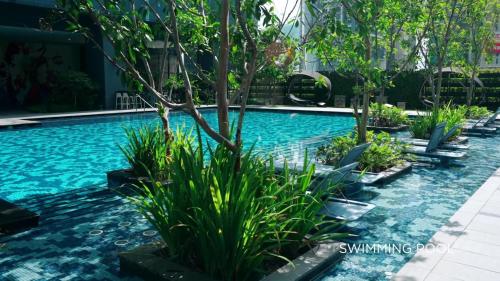 a swimming pool with blue water and plants at Star Residence 2br Unit Floor 46 in Kuala Lumpur