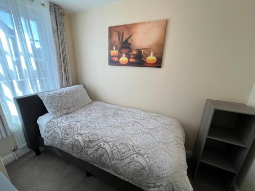 a bedroom with a bed and a picture on the wall at Glastonbury High Street Sanctuary- 2 BD, Sleeps 4 in Glastonbury