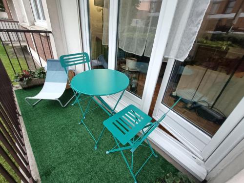 - une table et deux chaises sur une terrasse couverte dans l'établissement A à Boulogne confort pour sportifs, à Boulogne-Billancourt