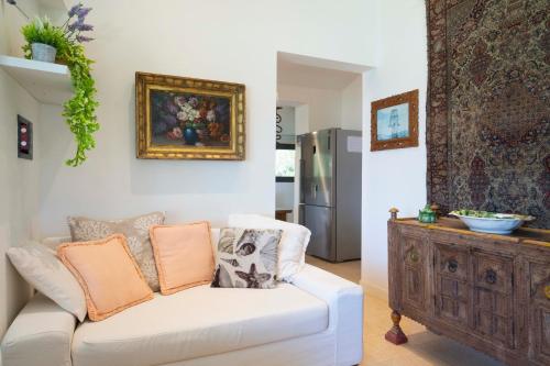 a living room with a white couch and a refrigerator at Domus de Rocas Holiday House in Porto Rotondo