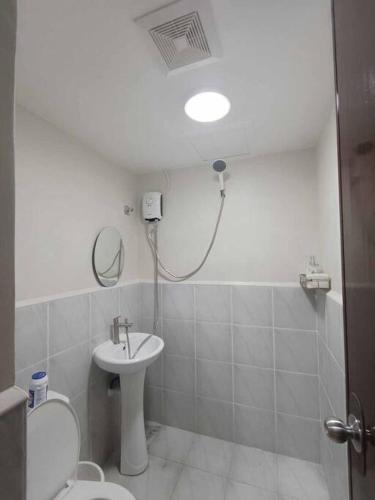 a bathroom with a sink and a toilet and a mirror at DDs holistay in Lapu Lapu City