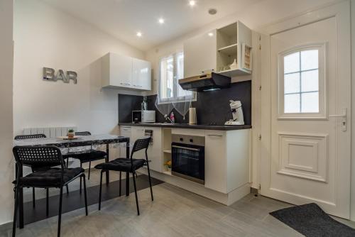 une cuisine avec une table et quelques chaises dans l'établissement La Sérénade Numéro 4, à Montreuil