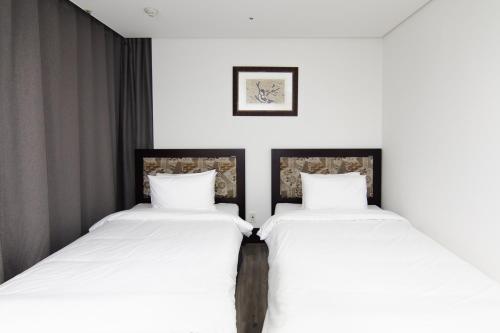two beds sitting next to each other in a room at Centum Convention Hotel In Centum in Busan
