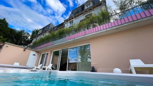 a swimming pool in front of a house at La Demeure d'Elodie in Épernay