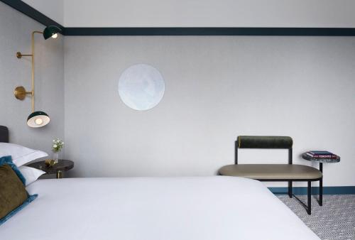 a bedroom with a white bed and a chair at Kimpton Saint George Hotel by IHG in Toronto