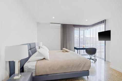 Un dormitorio con una cama, un escritorio y un televisor. en Kings View, en San Remo